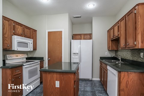 A kitchen with wooden cabinets and a black countertop.
