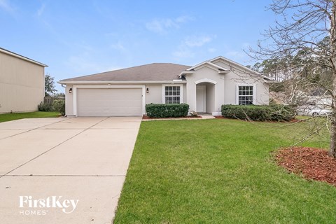 a white house with a driveway and a lawn