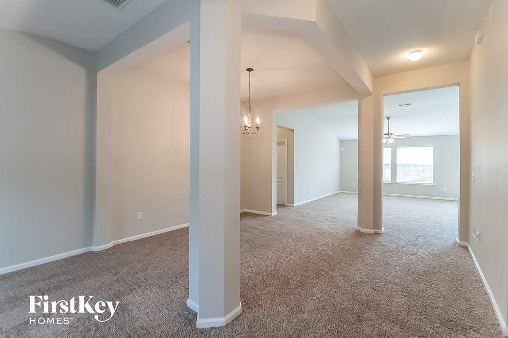 the living room and dining room of an empty house