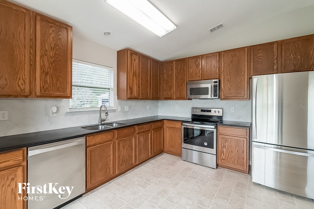a kitchen with wooden cabinets and stainless steel appliances