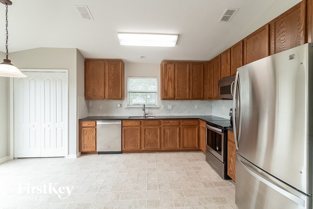 a kitchen with wooden cabinets and stainless steel appliances