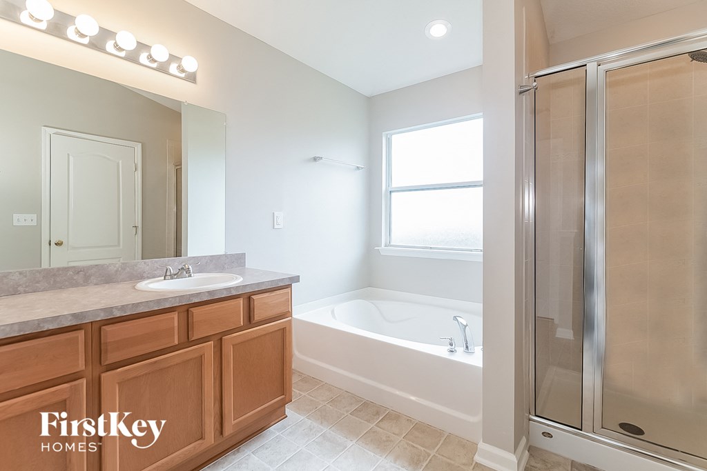 a bathroom with a sink and a shower and a bath tub