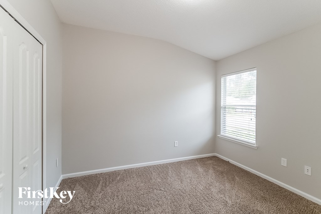 a bedroom with a carpeted floor and a window