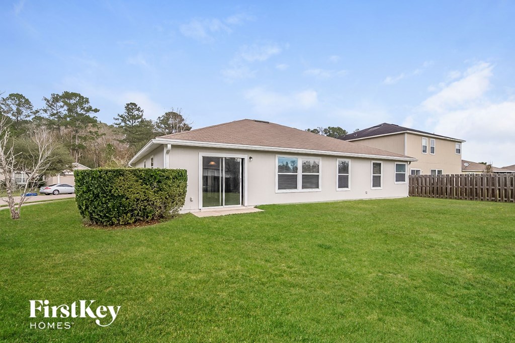 a backyard with a house and a green lawn