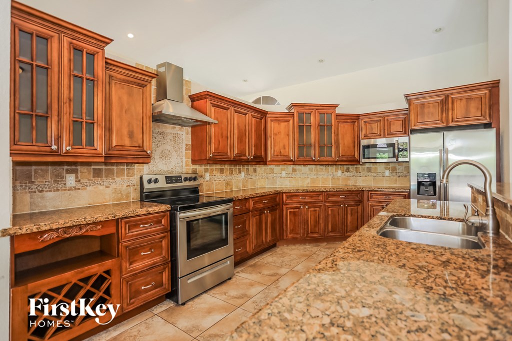 a kitchen with wooden cabinets and granite counter tops and stainless steel appliances