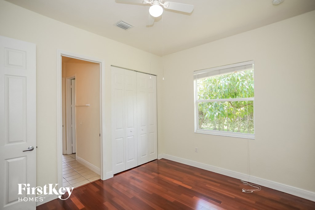 an empty room with wood floors and a window and a closet