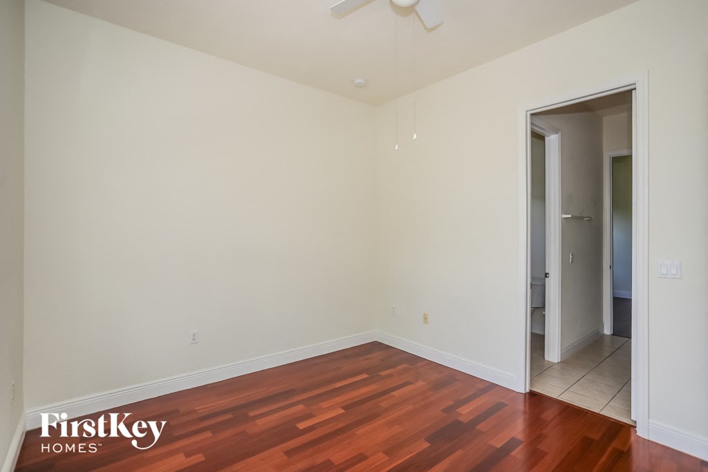 a living room with wood flooring and a door to a bathroom