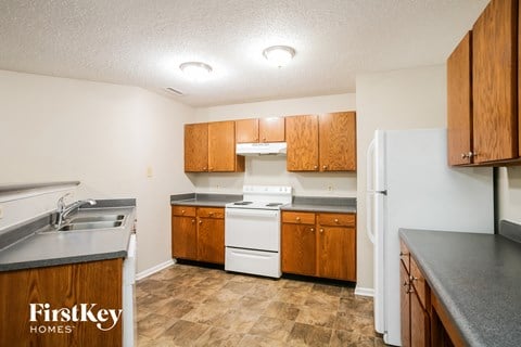 A kitchen with wooden cabinets and a white refrigerator.