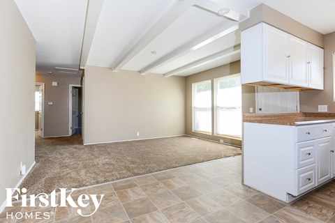A kitchen area with white cabinets and a brown countertop.