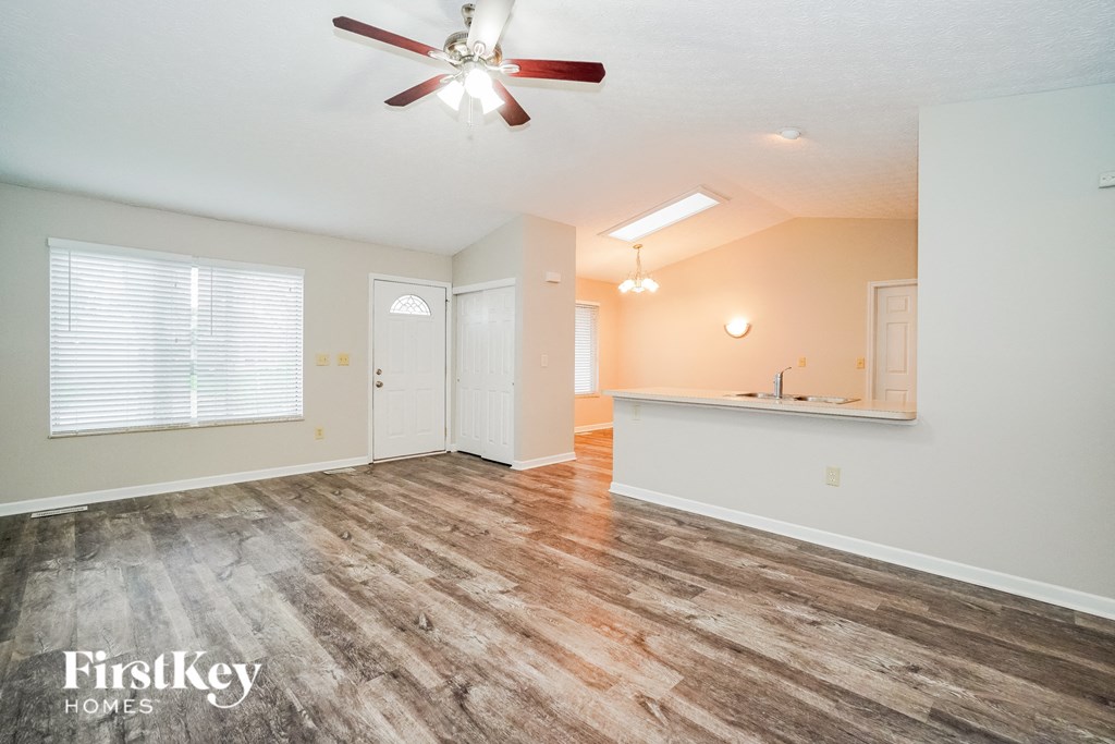 A room with a wood floor and a ceiling fan.
