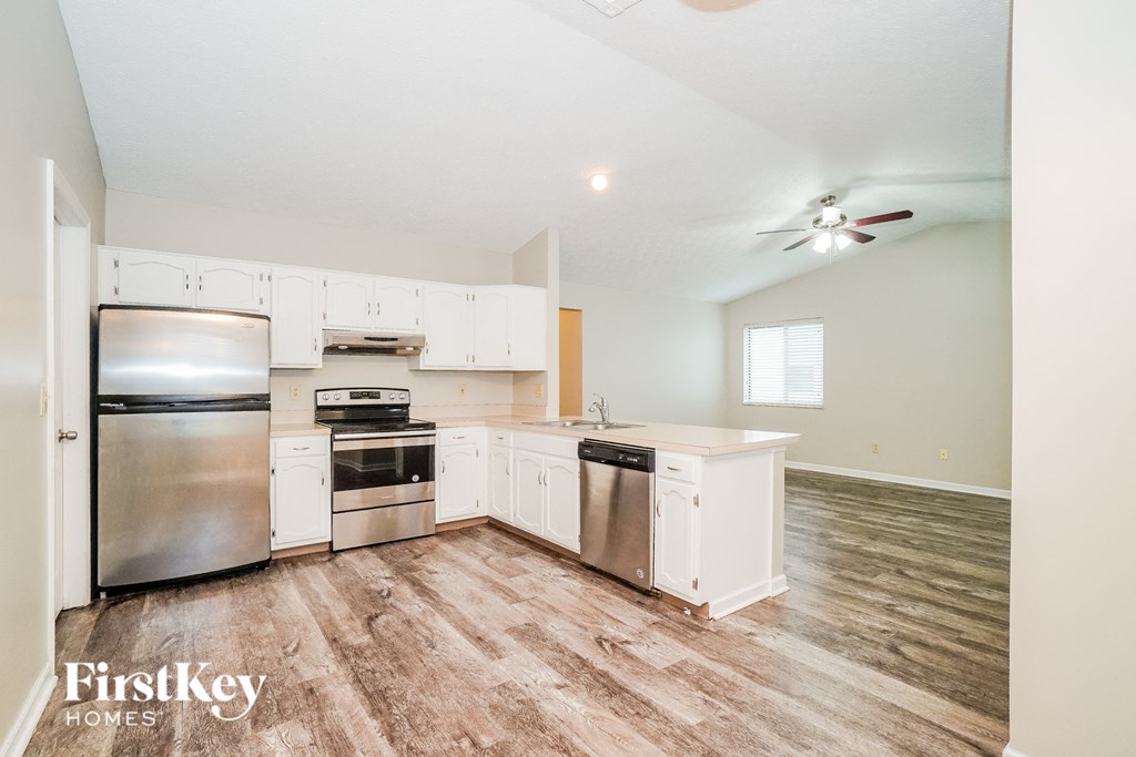 A kitchen with wooden floors and stainless steel appliances.