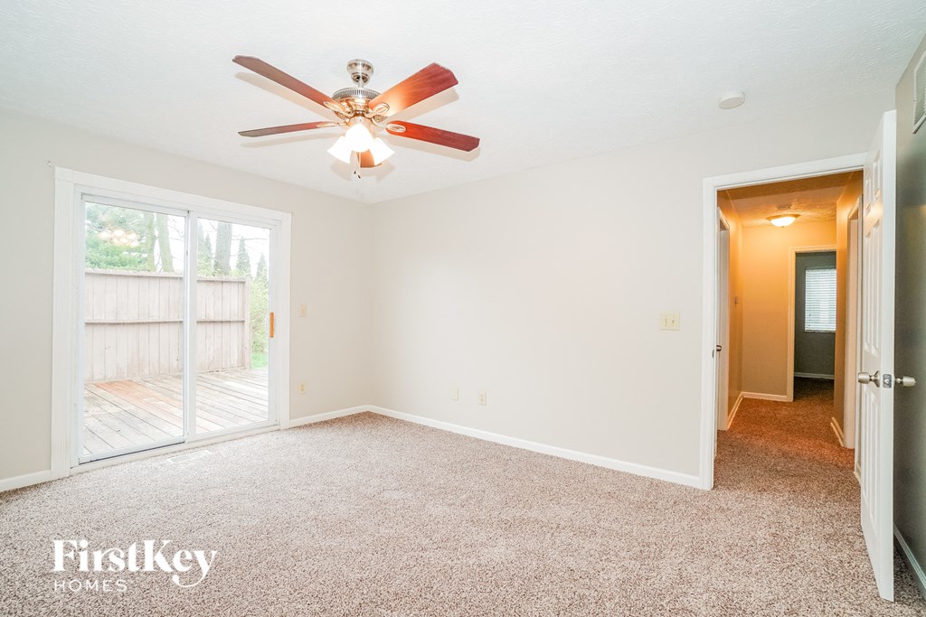 A room with a ceiling fan and a carpeted floor.