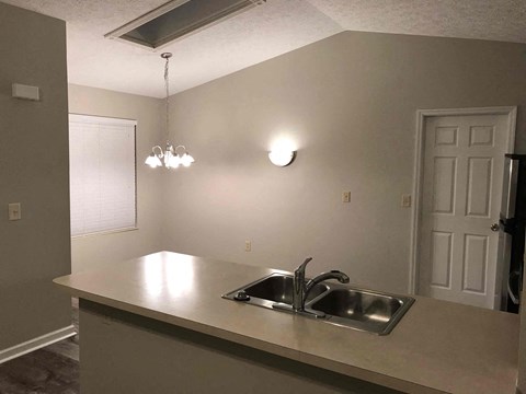 A kitchen with a sink and a light on the wall.
