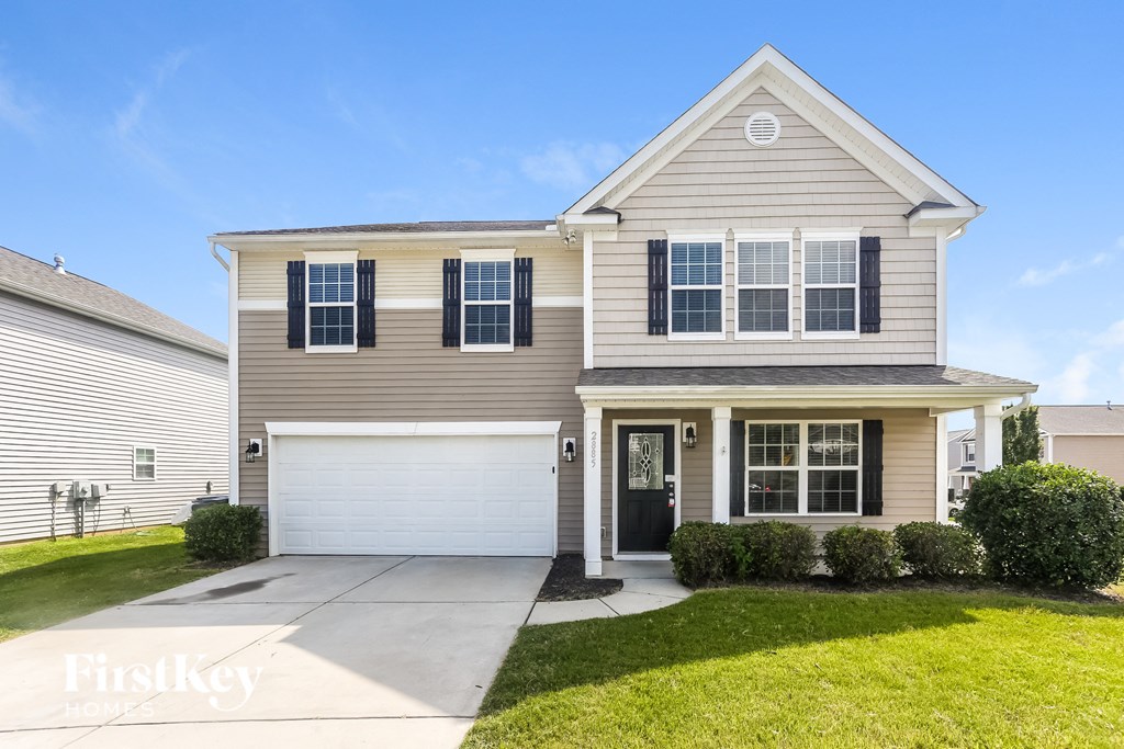 A two-story house with a garage and a driveway.