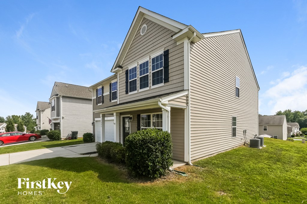 A house with a red car parked in front of it.
