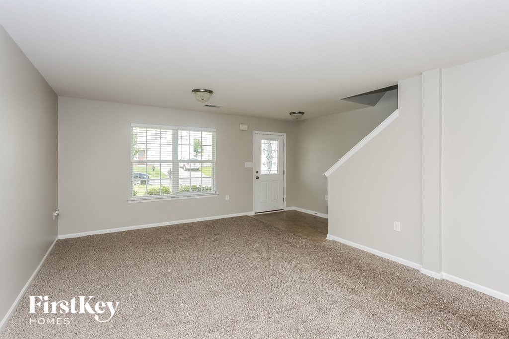 A spacious empty room with a window and a door.