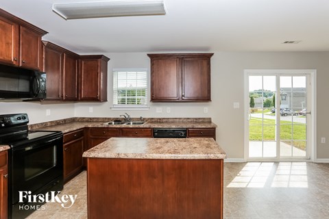 A kitchen with wooden cabinets and a granite countertop.