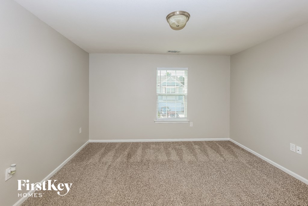 A room with a carpeted floor and a window.