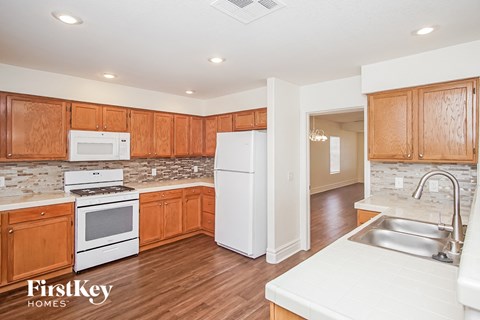 A kitchen with wooden cabinets and white appliances.