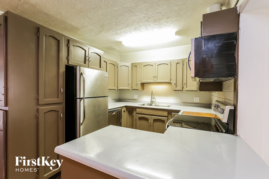 a kitchen with a white counter top and a refrigerator