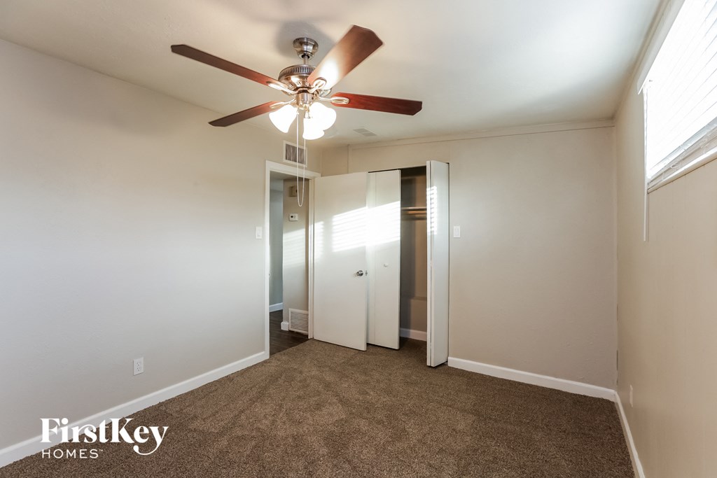 a bedroom with a ceiling fan and a closet