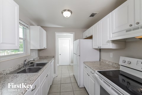 A kitchen with white cabinets and appliances.