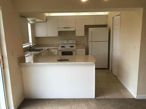a kitchen with white cabinets and a counter top