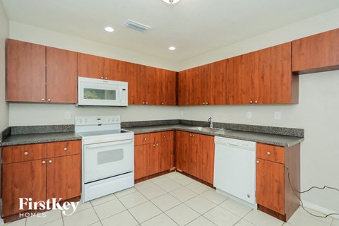 A kitchen with wooden cabinets and a white dishwasher.