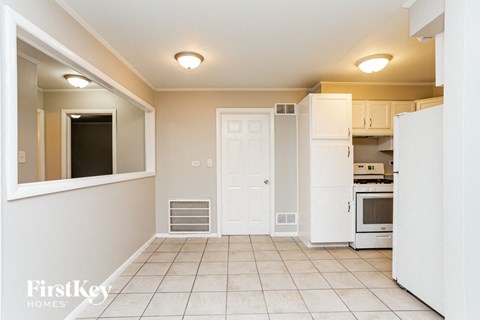 A kitchen with white cabinets and appliances.