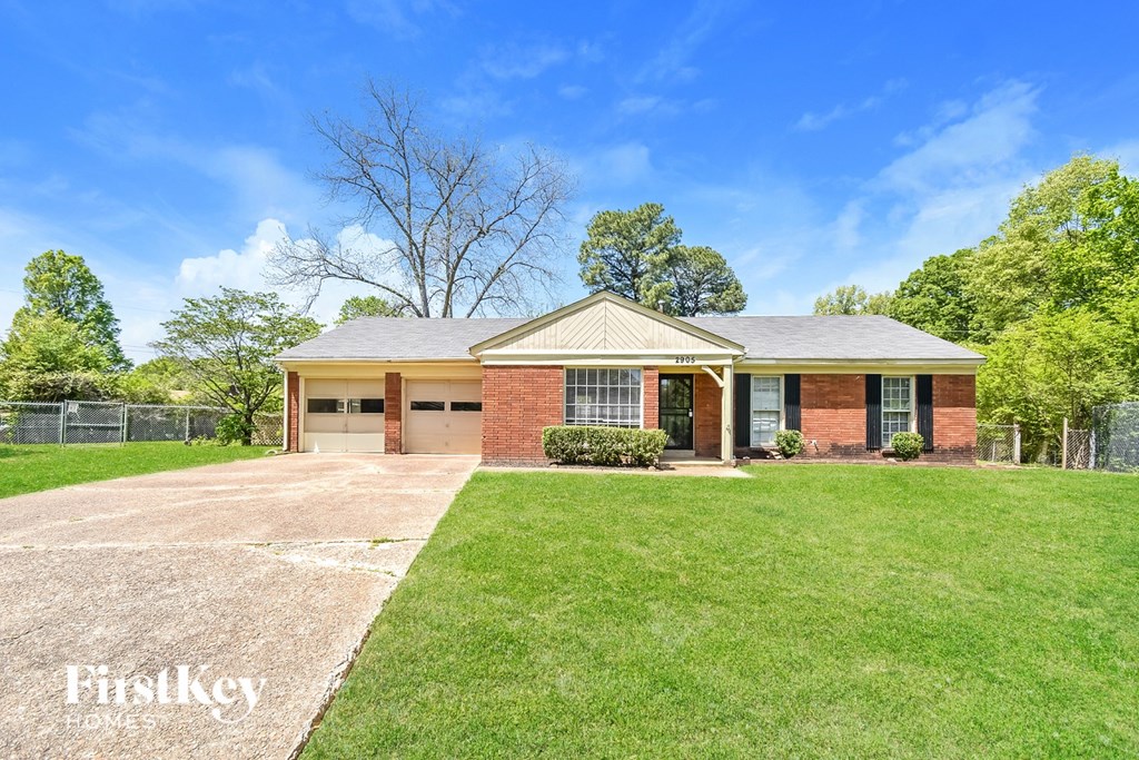 A house with a brick facade and a large front yard.