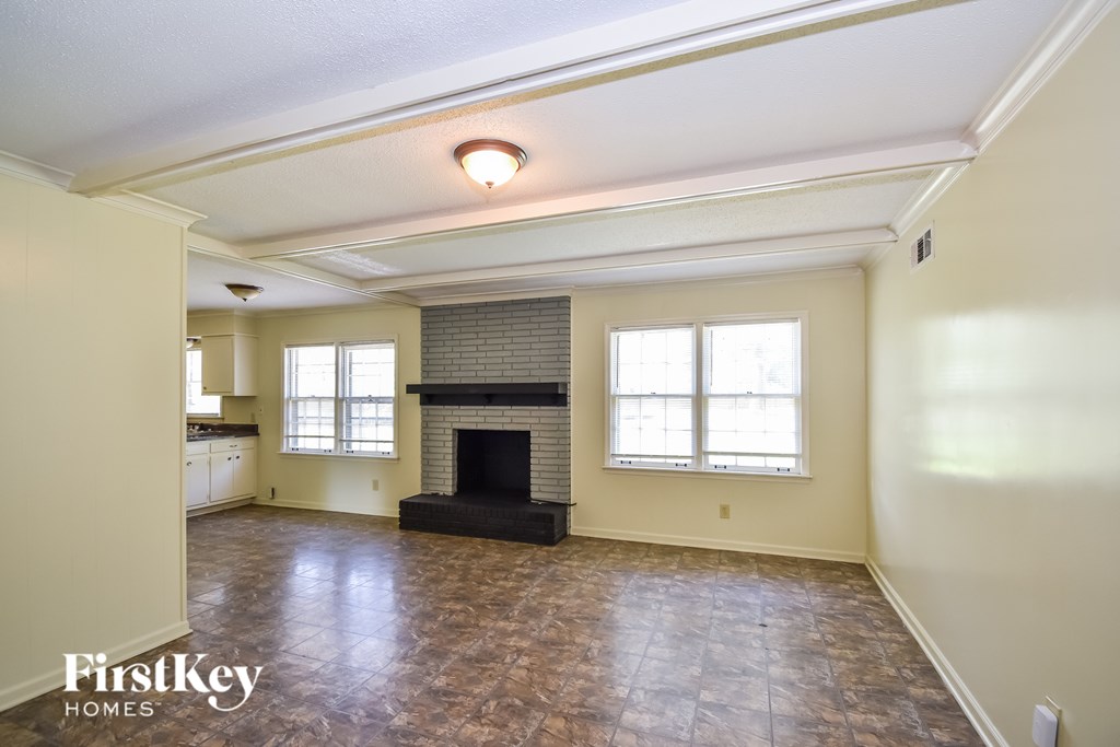A spacious room with a fireplace and a tiled floor.