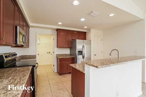 A kitchen with brown cabinets and a granite counter top.