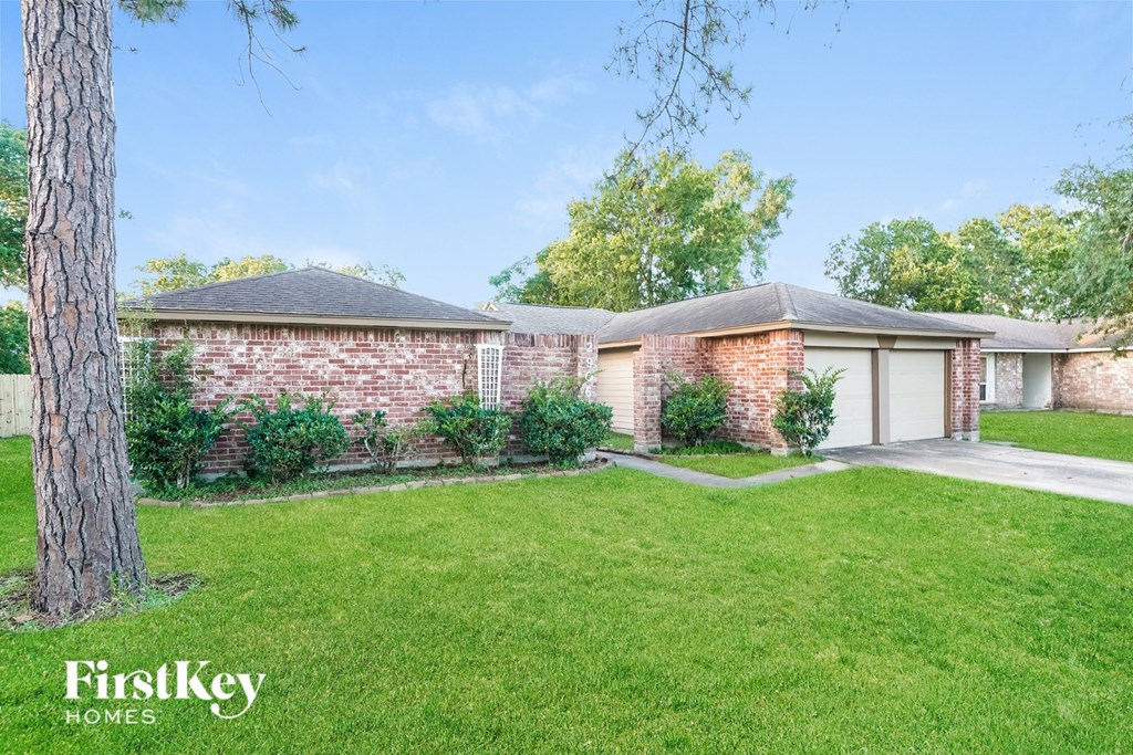 A brick house with a tree in front of it.