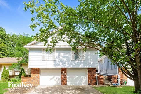 a white and brick house with a white garage door