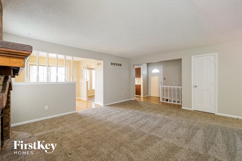 the living room and dining room of an empty house with a fireplace