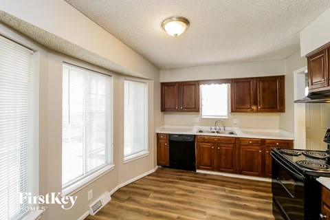 a kitchen with wood flooring and a large window