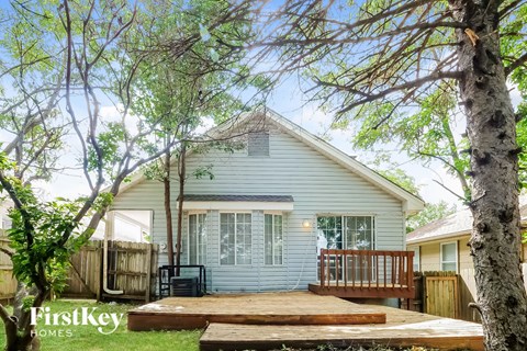 a white house with a deck and trees
