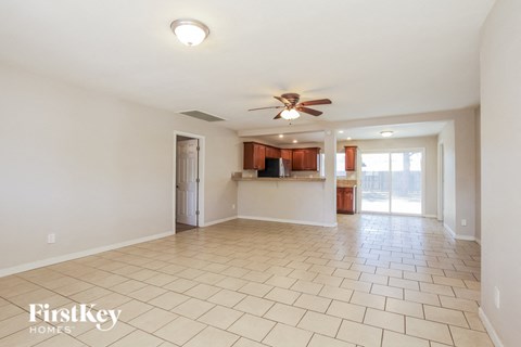 A spacious living room with a fan and tiled flooring.