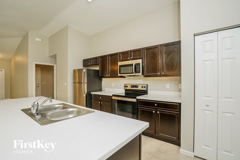 A kitchen with brown cabinets and a white counter top.