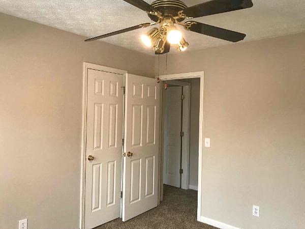 a bedroom with a ceiling fan and a closet