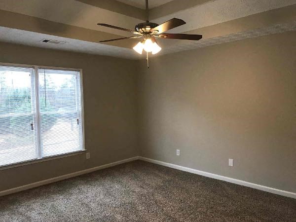 an empty room with a ceiling fan and a window