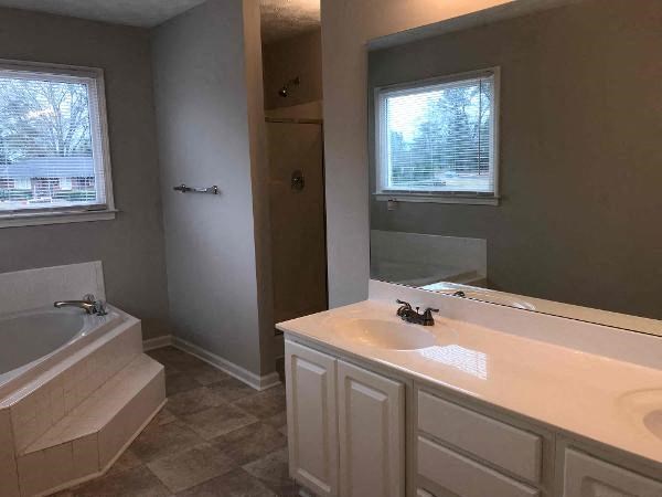 a bathroom with a tub and a sink and a mirror