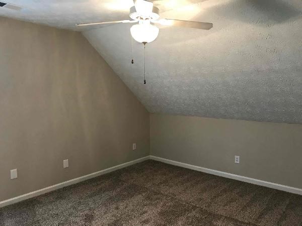 an empty room with a ceiling fan and a light