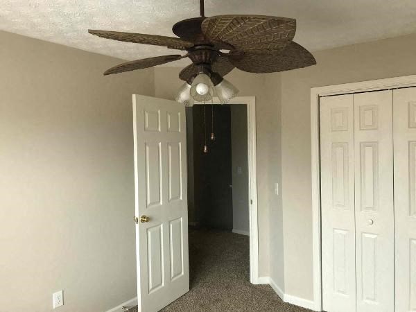 a living room with a ceiling fan and a door