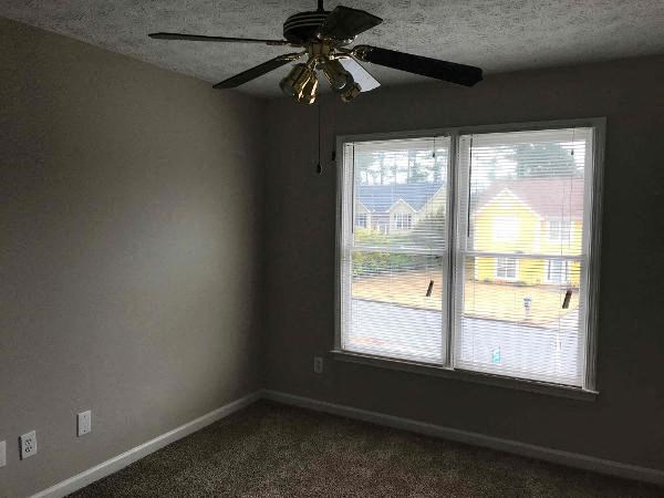a living room with a ceiling fan and a window