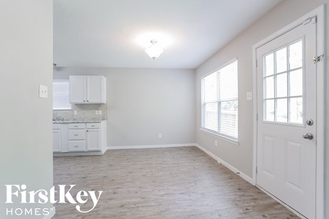a white kitchen with white cabinets and a wood floor