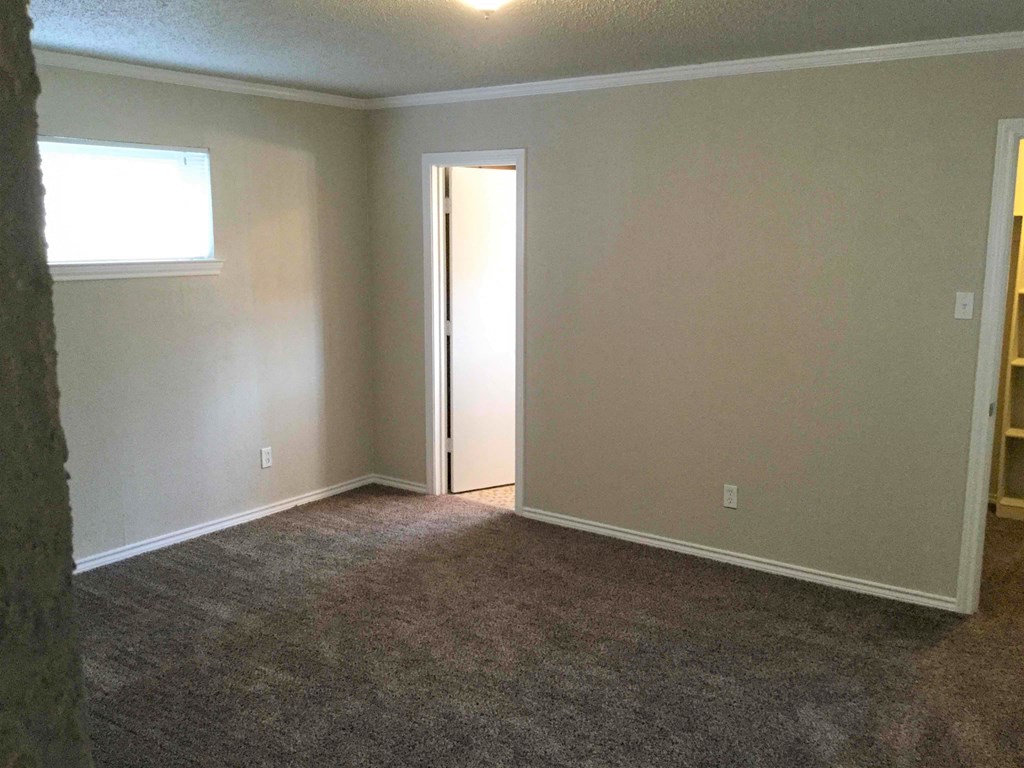 A room with a carpeted floor and a door.