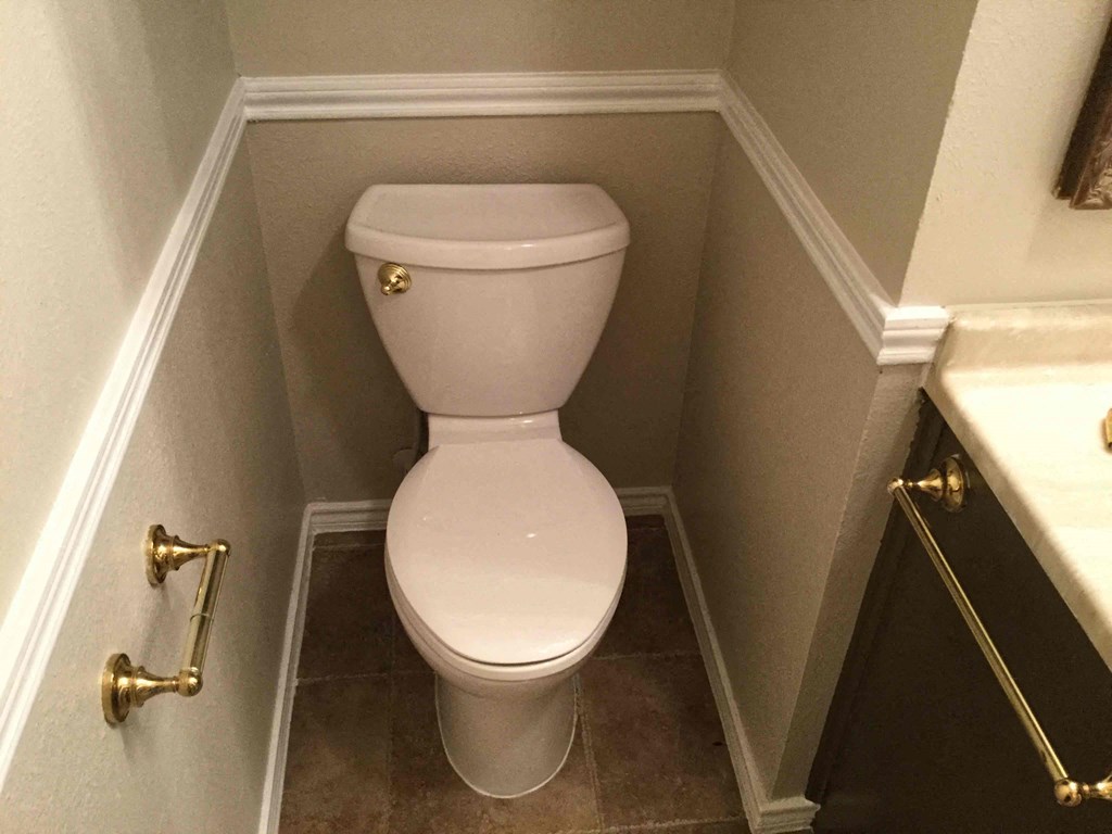 A white toilet in a small bathroom.