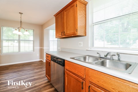 A kitchen with wooden cabinets and a stainless steel dishwasher.