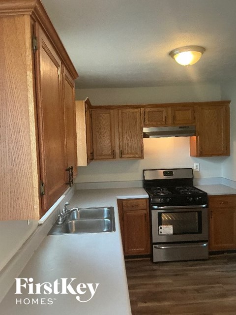 A kitchen with wooden cabinets and a stove top oven.